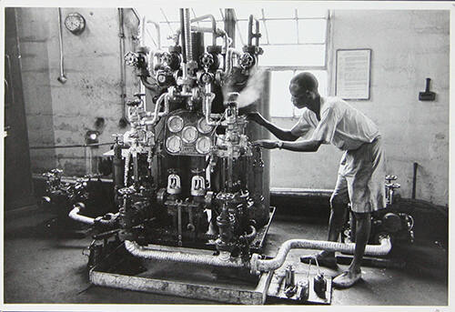 Man bij machine (Man at machine), Nigeria